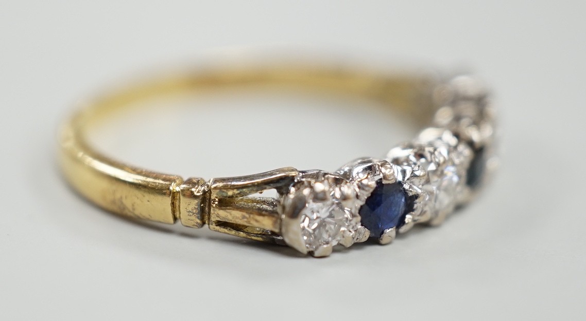 A modern 18ct gold, three stone sapphire and four stone diamond set half hoop ring, size P/Q, gross weight 2.9 grams.